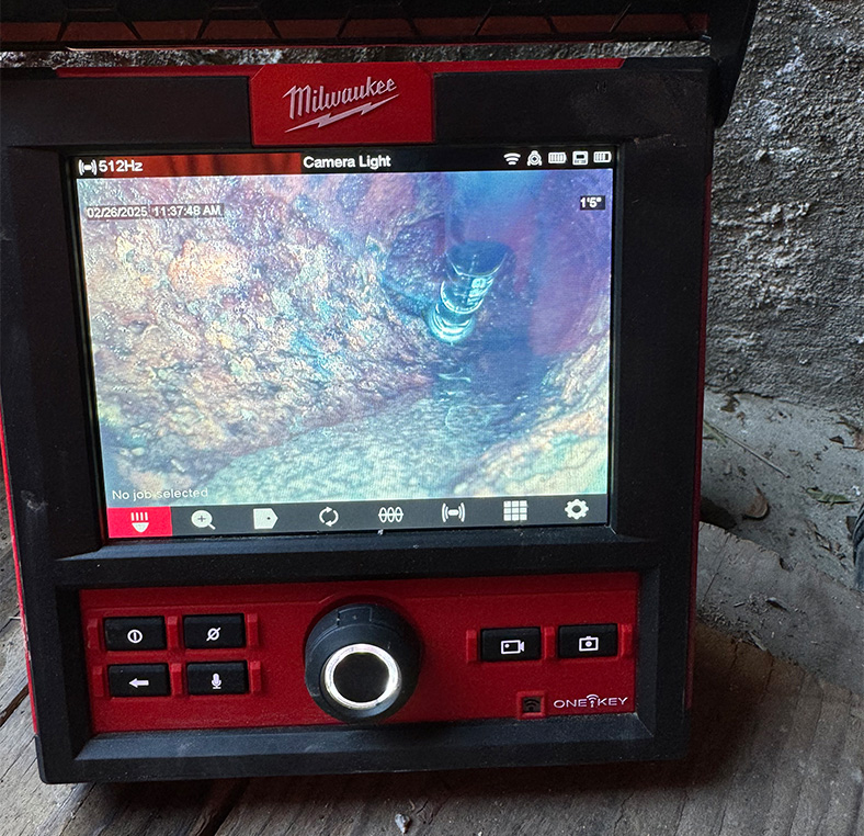 Close‑up of a Milwaukee sewer inspection camera display showing the interior of a pipe